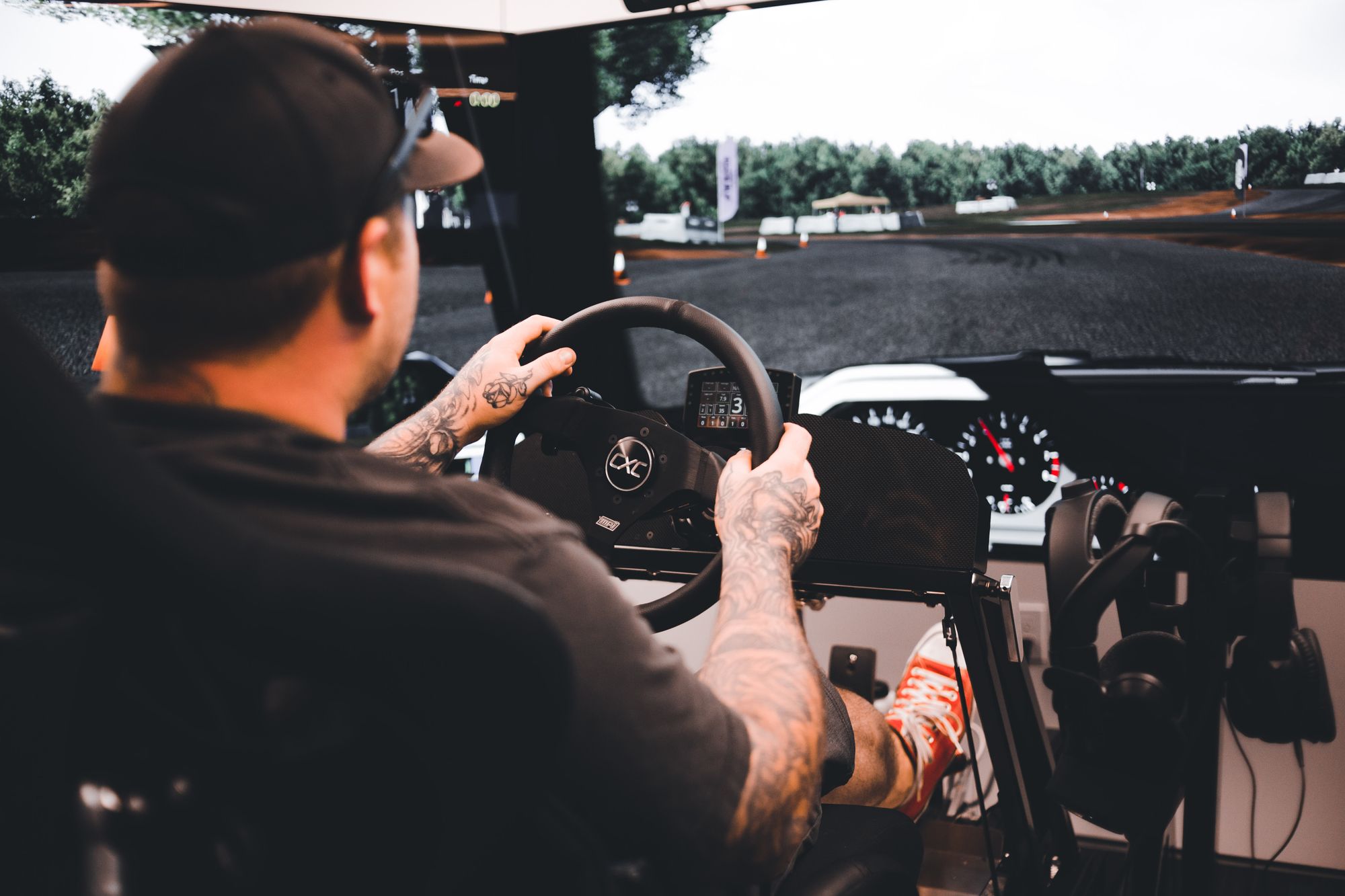 Cockpit de simulateur de course automobile équipé d'un volant à retour de force et d'un pédalier, utilisé en sim racing